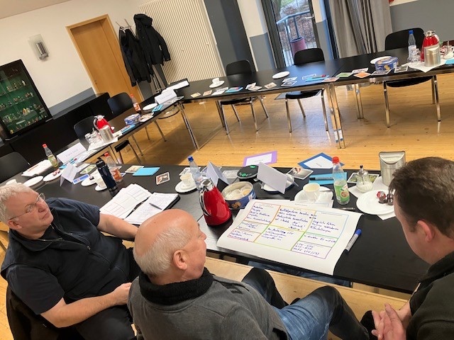 Netzwerktreffen mit Arbeitsunterlagen an zusammengestellten Tischen